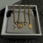 Balenciaga charm necklace set in box with two circular pendants and long gold chain