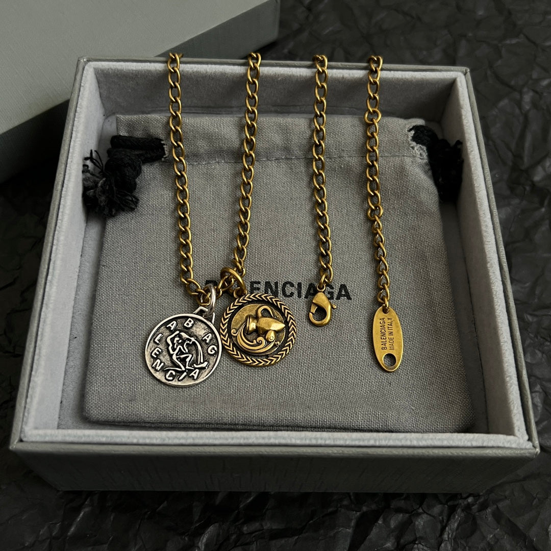 Balenciaga charm necklace set in box with two circular pendants and long gold chain