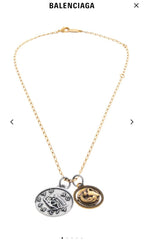 Gold-tone charm necklace with two circular pendants, one silver-tone and one gold-tone