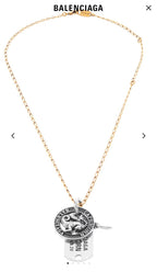 Gold charm necklace with circular zodiac coin pendant and hanging engraved tag