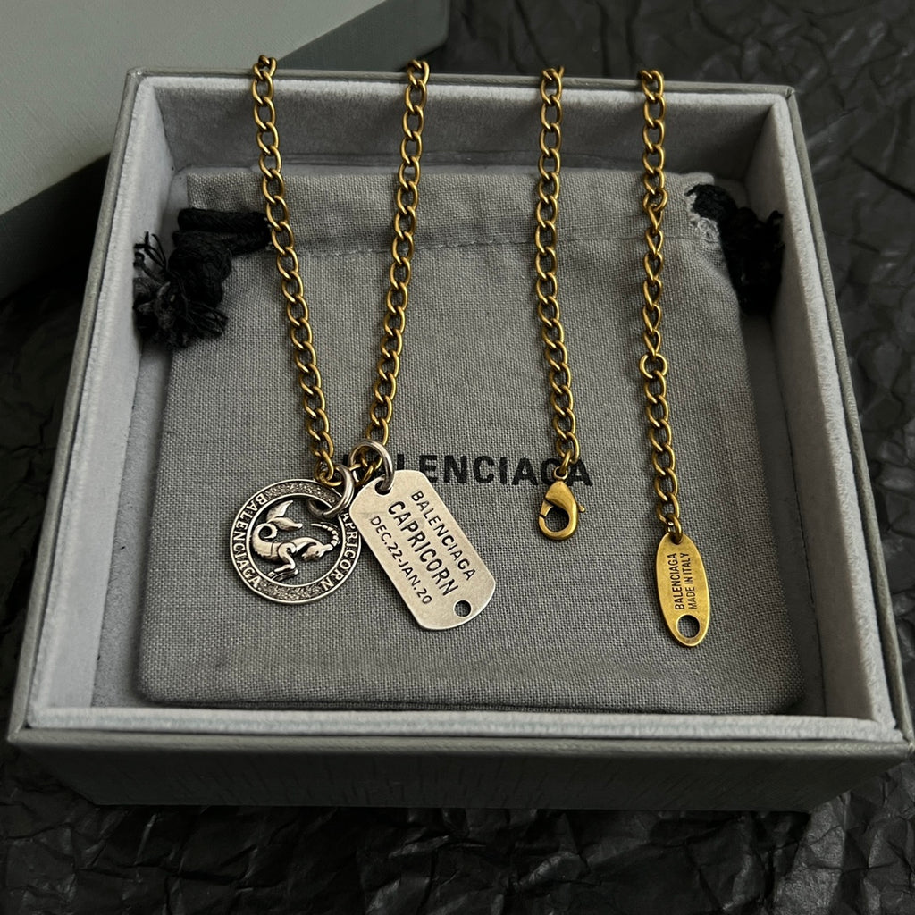 Gold charm necklace with zodiac coin, Capricorn tag, and small drop charm