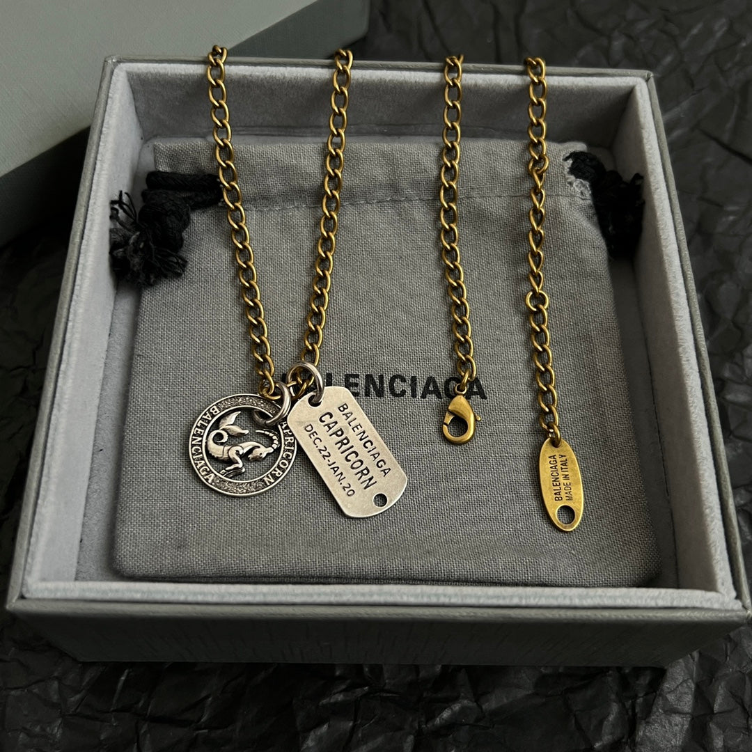 Gold charm necklace with zodiac coin, Capricorn tag, and small drop charm