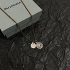 Balenciaga gold-tone charm necklace with circular pendant and round ID medallion
