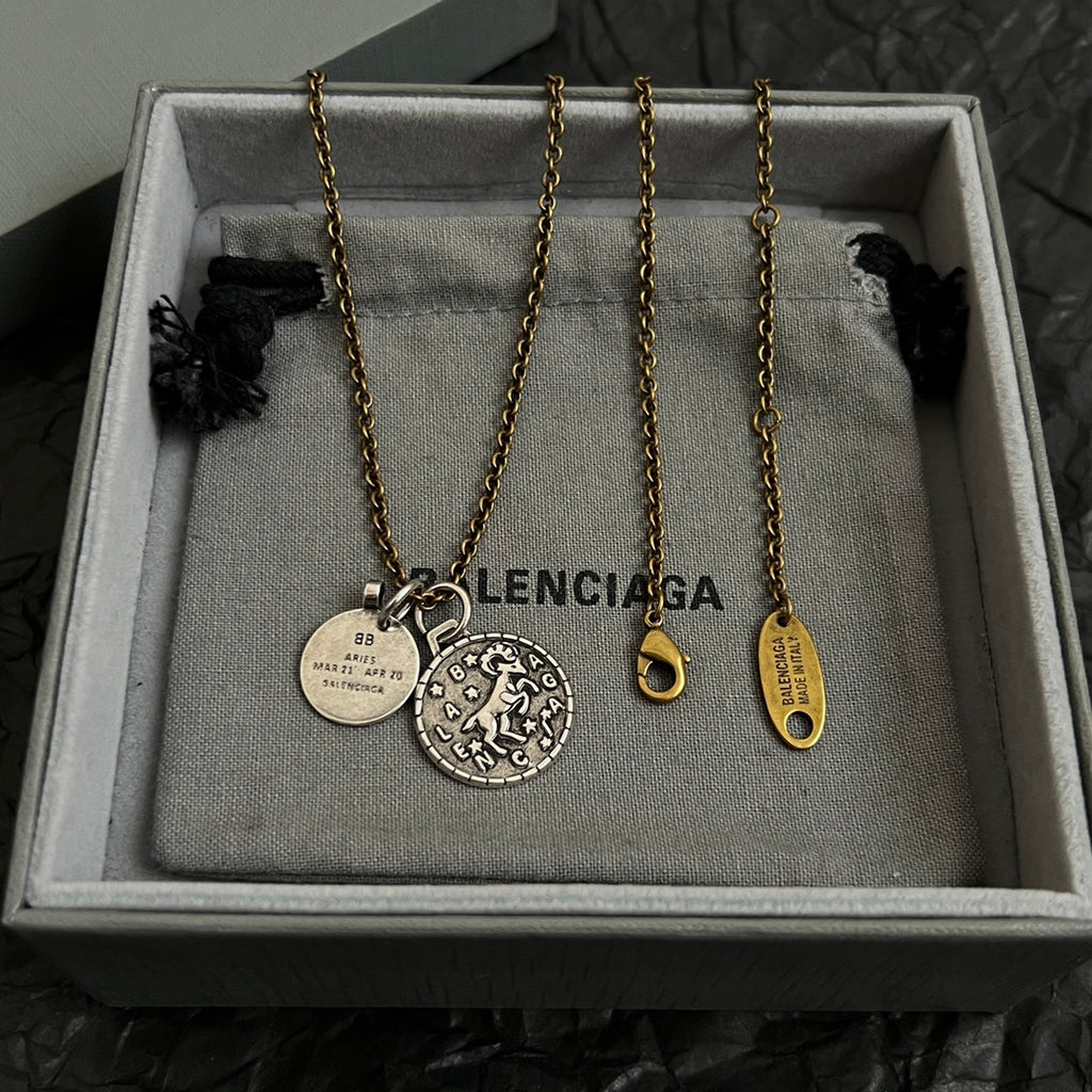 Balenciaga gold-tone charm necklace set with circular pendant and hanging tags