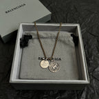 Balenciaga gold-tone charm necklace with circular pendant and round ID tags