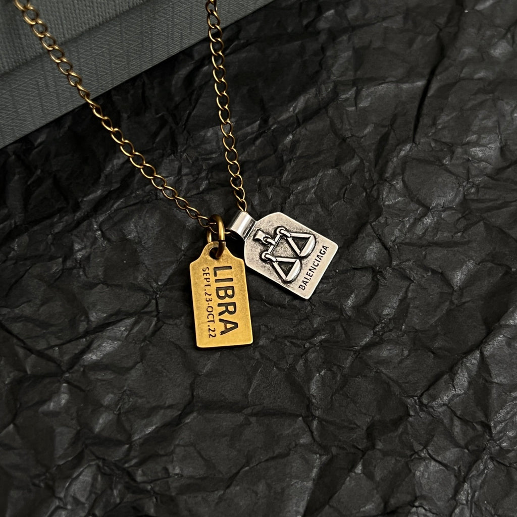 Gold-tone charm necklace with two logo tag pendants and chain links
