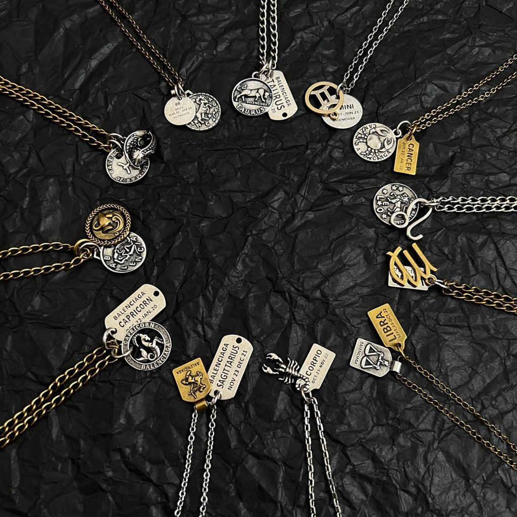 Multi-charm necklace with coin and tag pendants in gold and silver tones