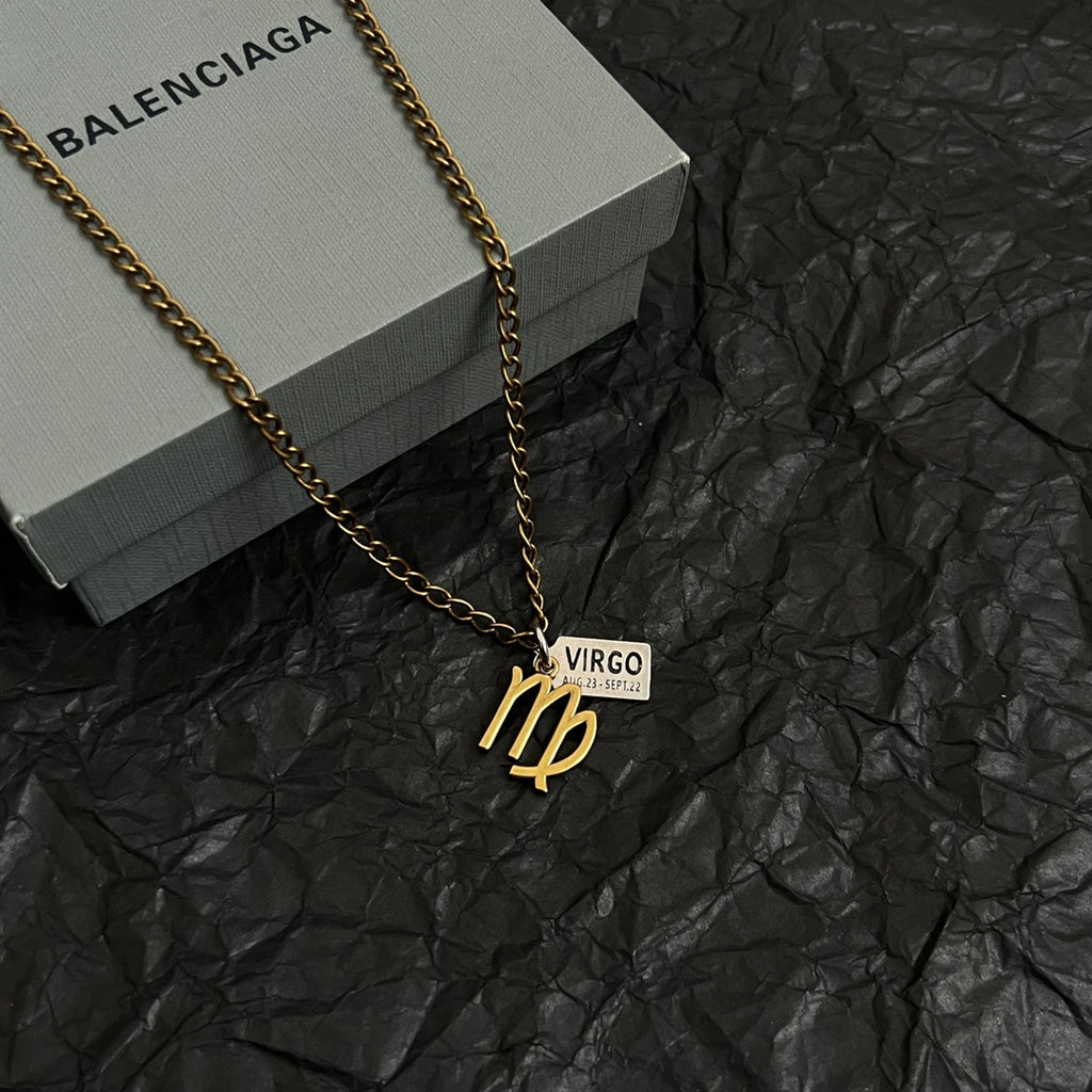 Gold-tone Virgo charm necklace on black paper, chain with VIRGO date tag pendant