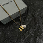 Gold-tone Virgo charm necklace on black paper, chain with VIRGO date tag pendant