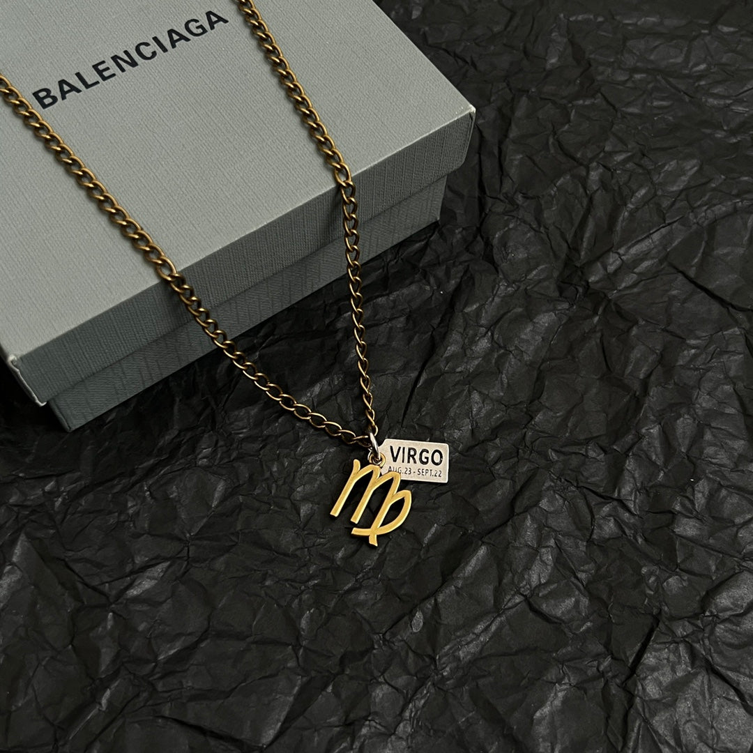 Gold-tone Virgo charm necklace on black paper, chain with VIRGO date tag pendant