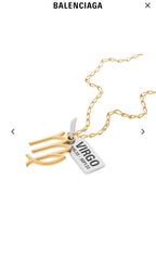 Gold-tone Virgo charm necklace close-up, layered pendant with date tag