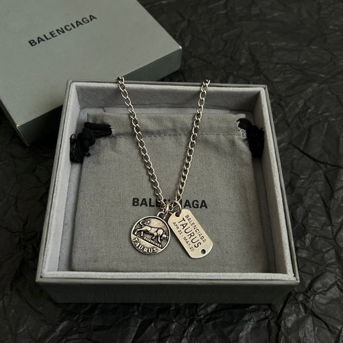 Balenciaga charm necklace with two pendants and chain, shown in gift box