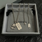 Balenciaga charm necklace in box with two round pendants and oval tag charm