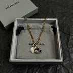 Balenciaga pendant necklace in gift box with circular fish medallion on gold chain