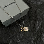 Silver chain necklace with gold Balenciaga emblem pendant on round tag