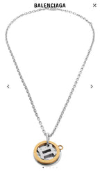 Silver chain necklace with round gold pendant and center emblem charm