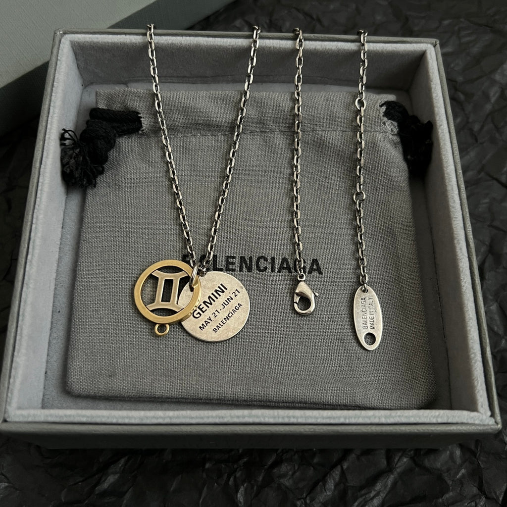 Set of silver chain necklaces with round gold and silver Balenciaga charms in box