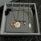 Set of silver chain necklaces with round gold and silver Balenciaga charms in box
