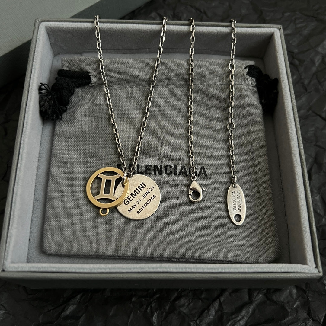 Set of silver chain necklaces with round gold and silver Balenciaga charms in box