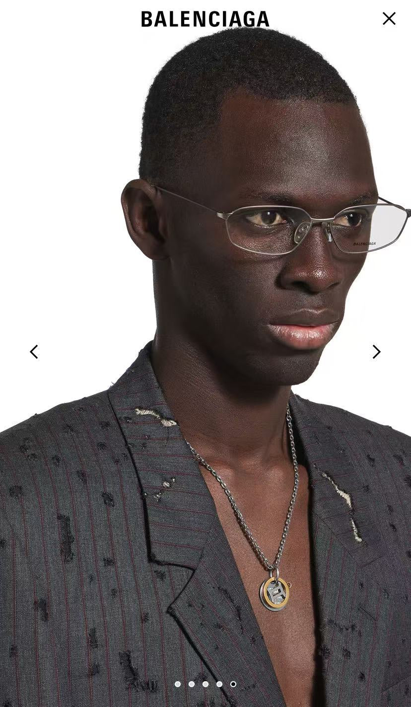 Silver chain necklace with round gold and silver Balenciaga pendant on model