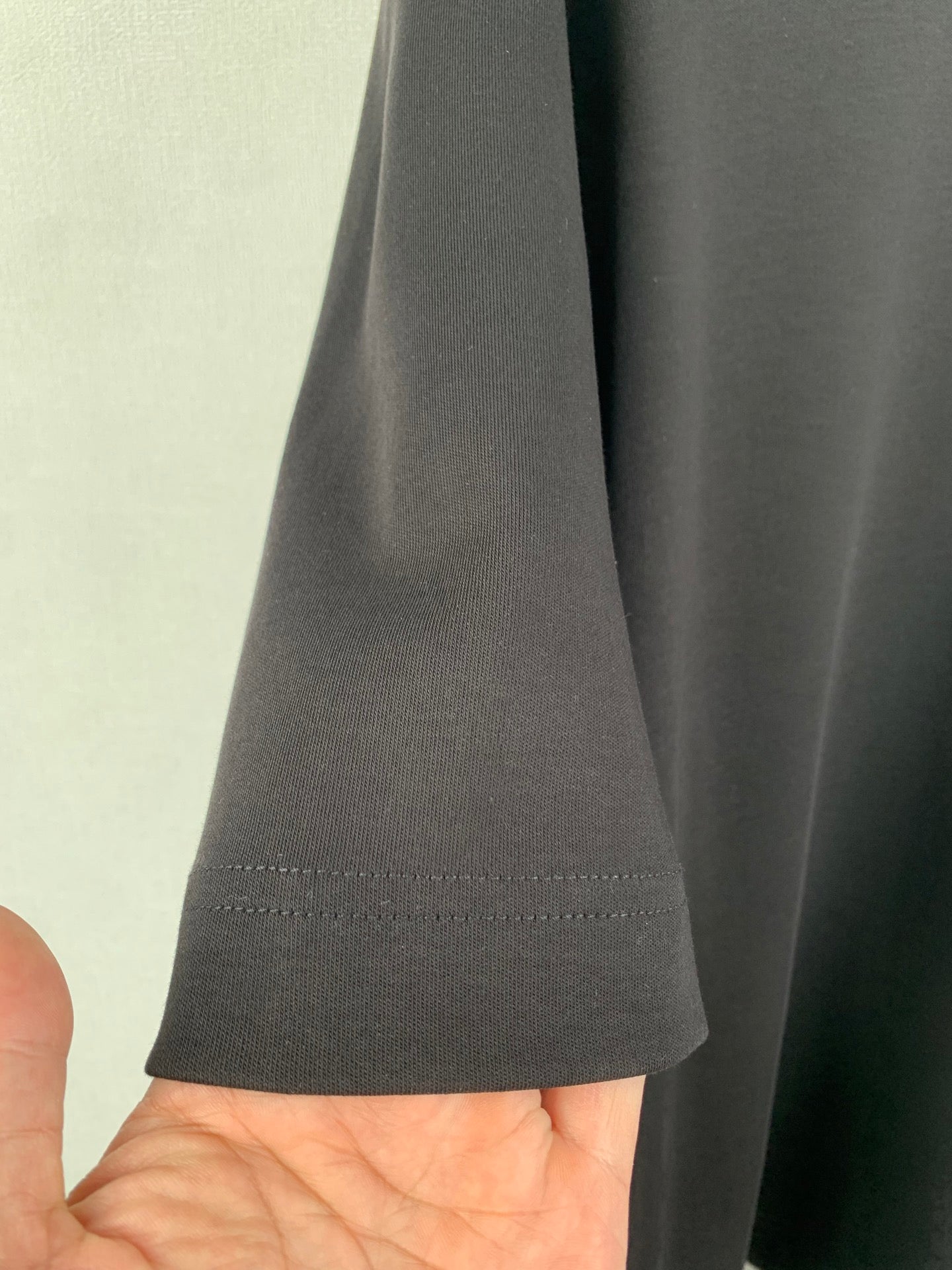 Fendi T-shirt side hem and curved stitching detail, dark gray fabric.