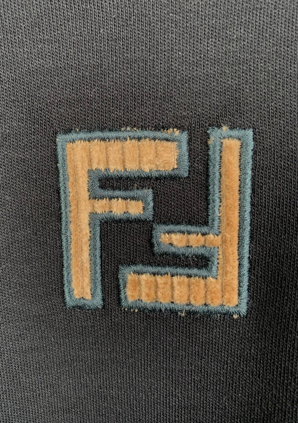Fendi logo patch embroidery on dark gray knit T-shirt fabric.