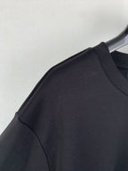 Fendi T-shirt shoulder and sleeve seam detail on dark gray/black fabric.