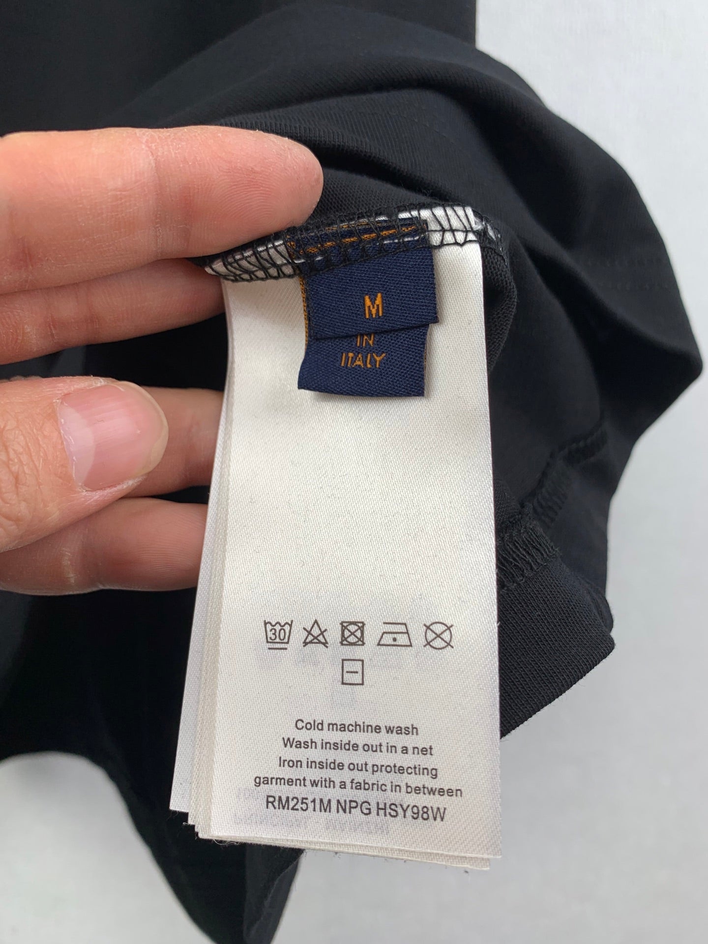 Louis Vuitton shorts care label with size "M" tag on dark fabric
