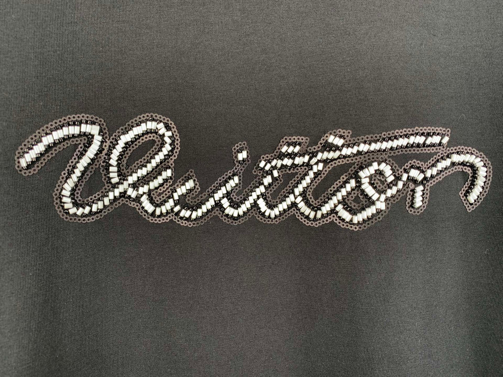 Louis Vuitton rhinestone script logo detail on dark T-shirt