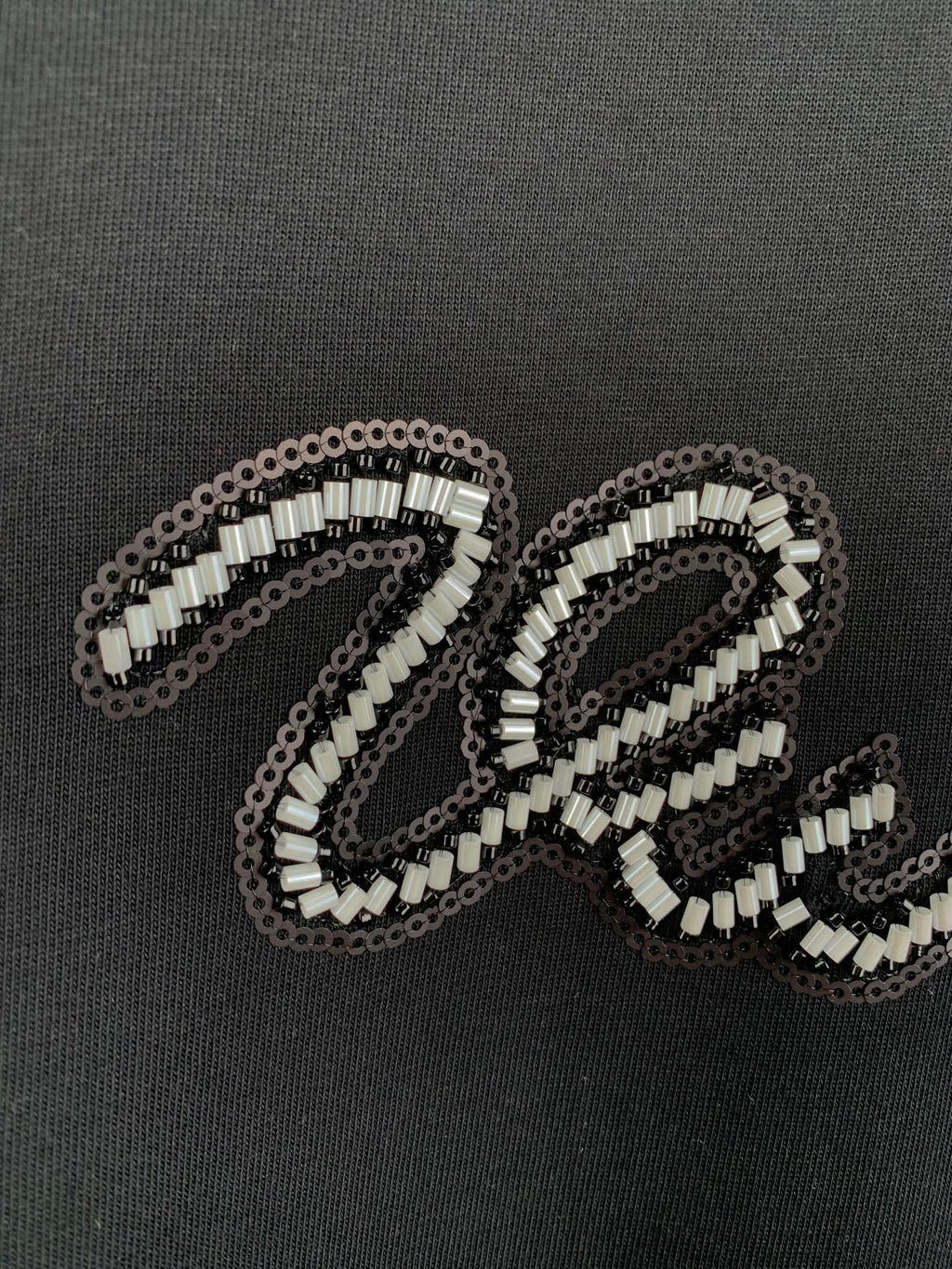 Louis Vuitton rhinestone letter detail on dark T-shirt