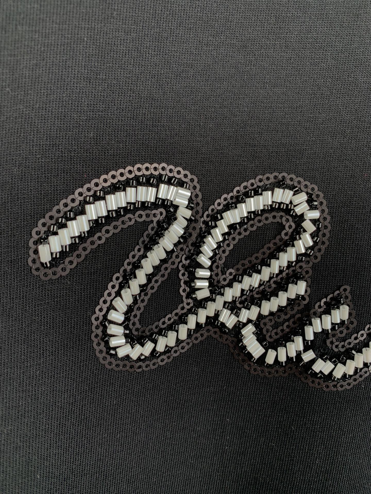 Louis Vuitton rhinestone letter detail on dark T-shirt