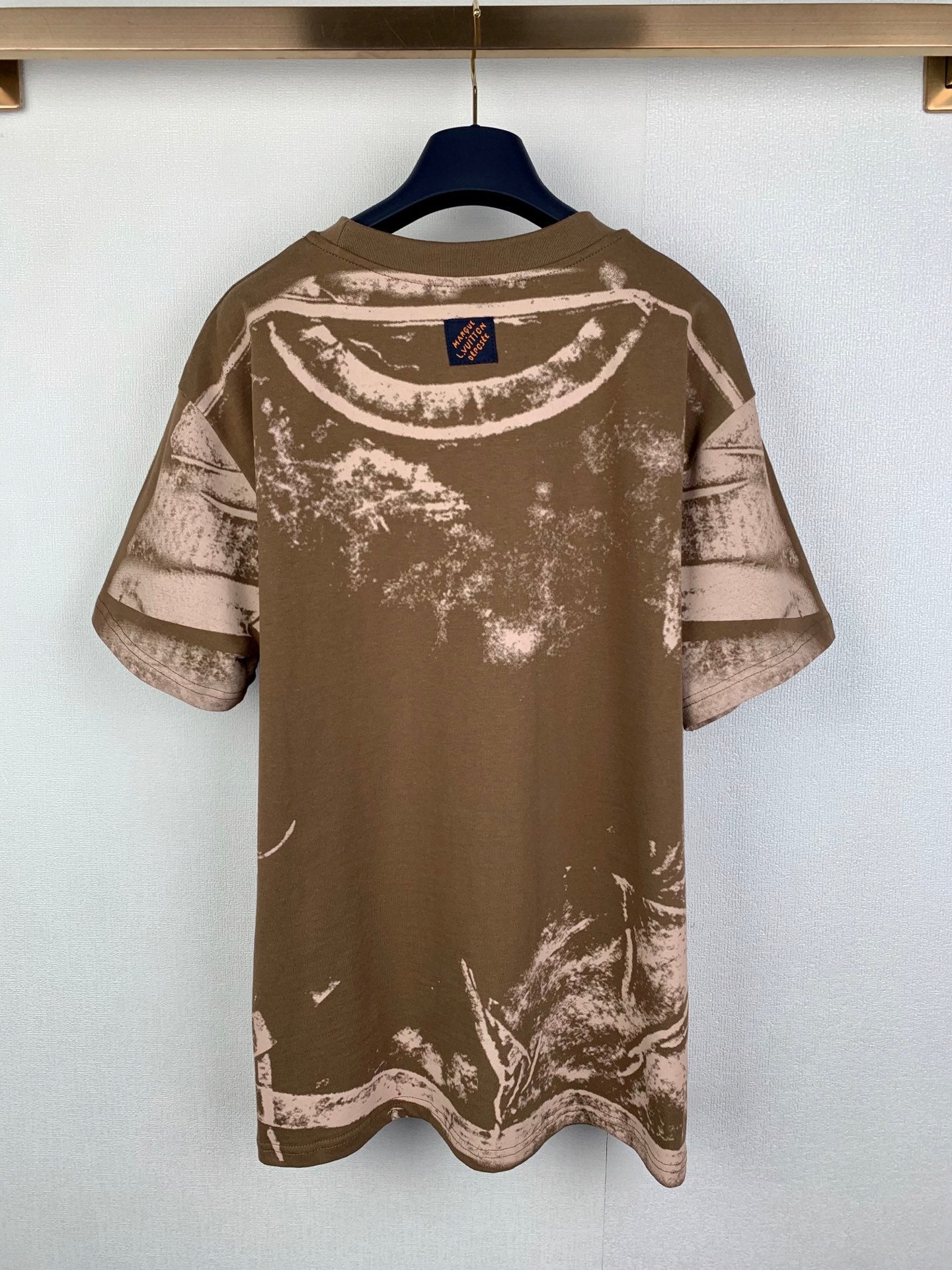 Brown short-sleeve T-shirt with white abstract logo print on the back
