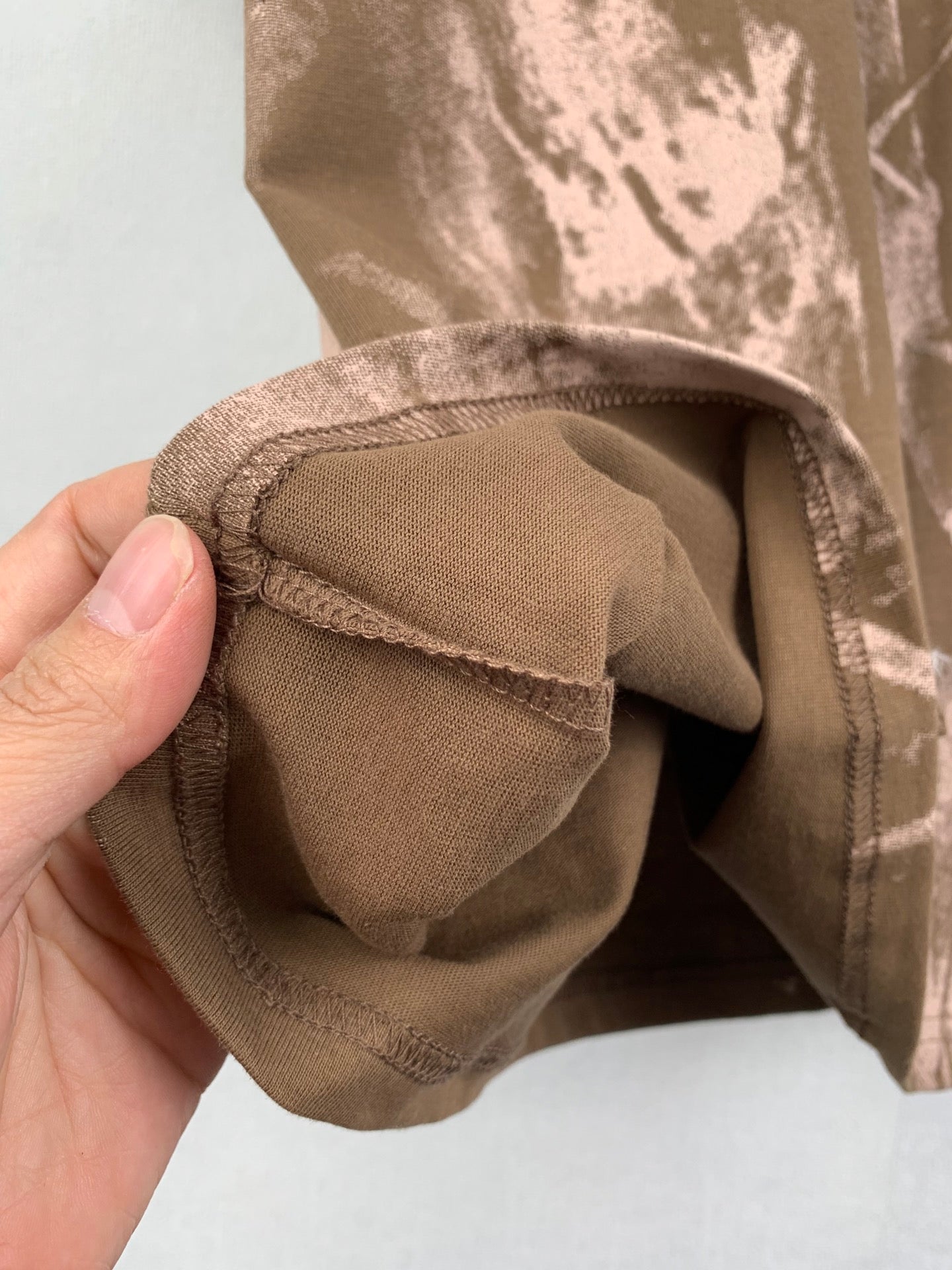 Brown T-shirt folded sleeve hem showing inner stitching
