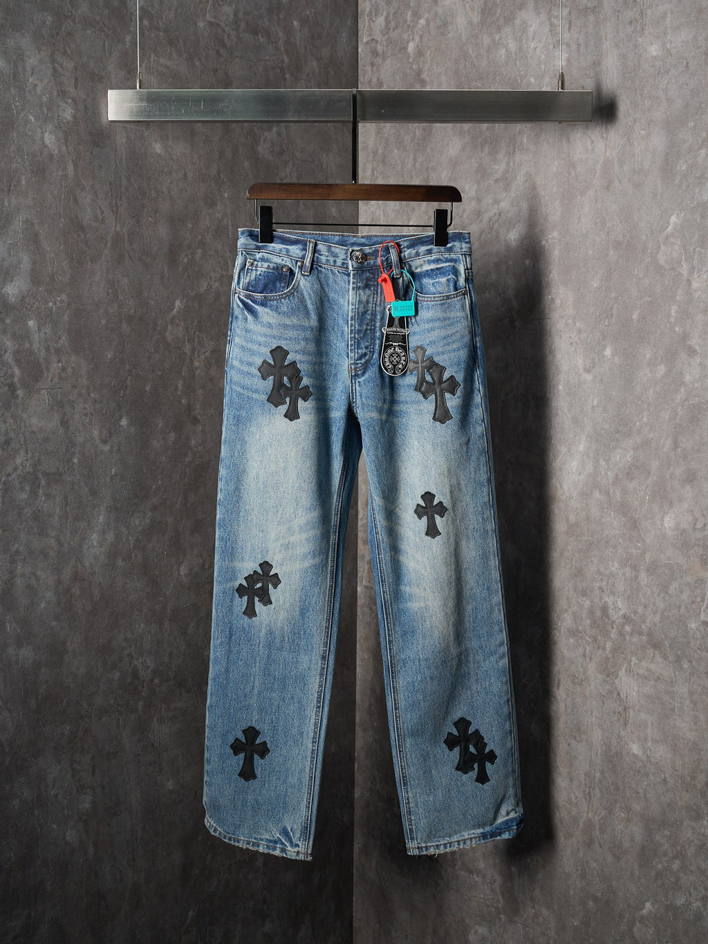 Light blue denim pants with black cross patches and straight leg