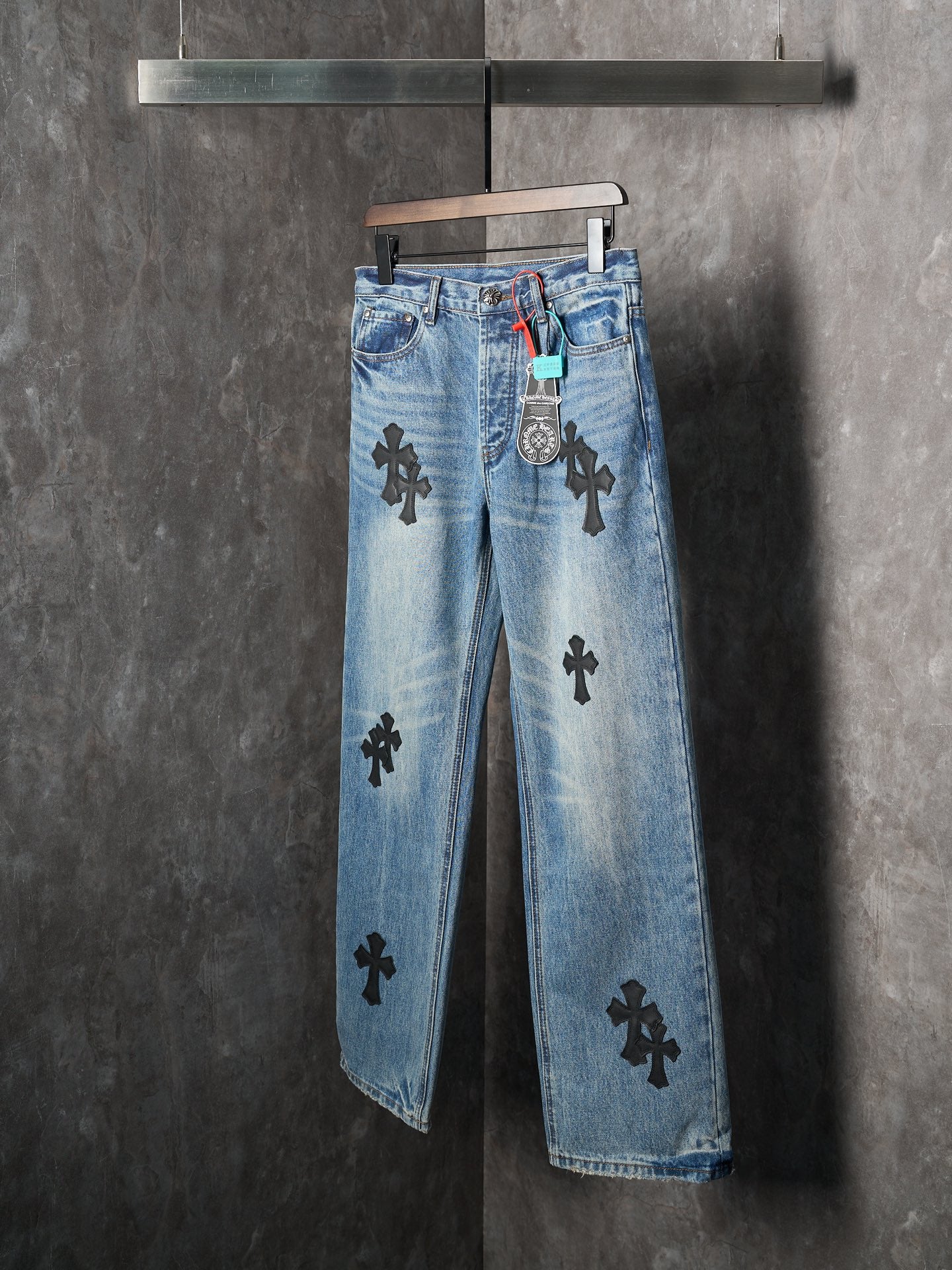 Light blue denim pants with black cross patches and front center seam