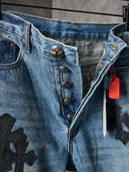 Light blue denim pants close-up: decorative buttons and black cross patch