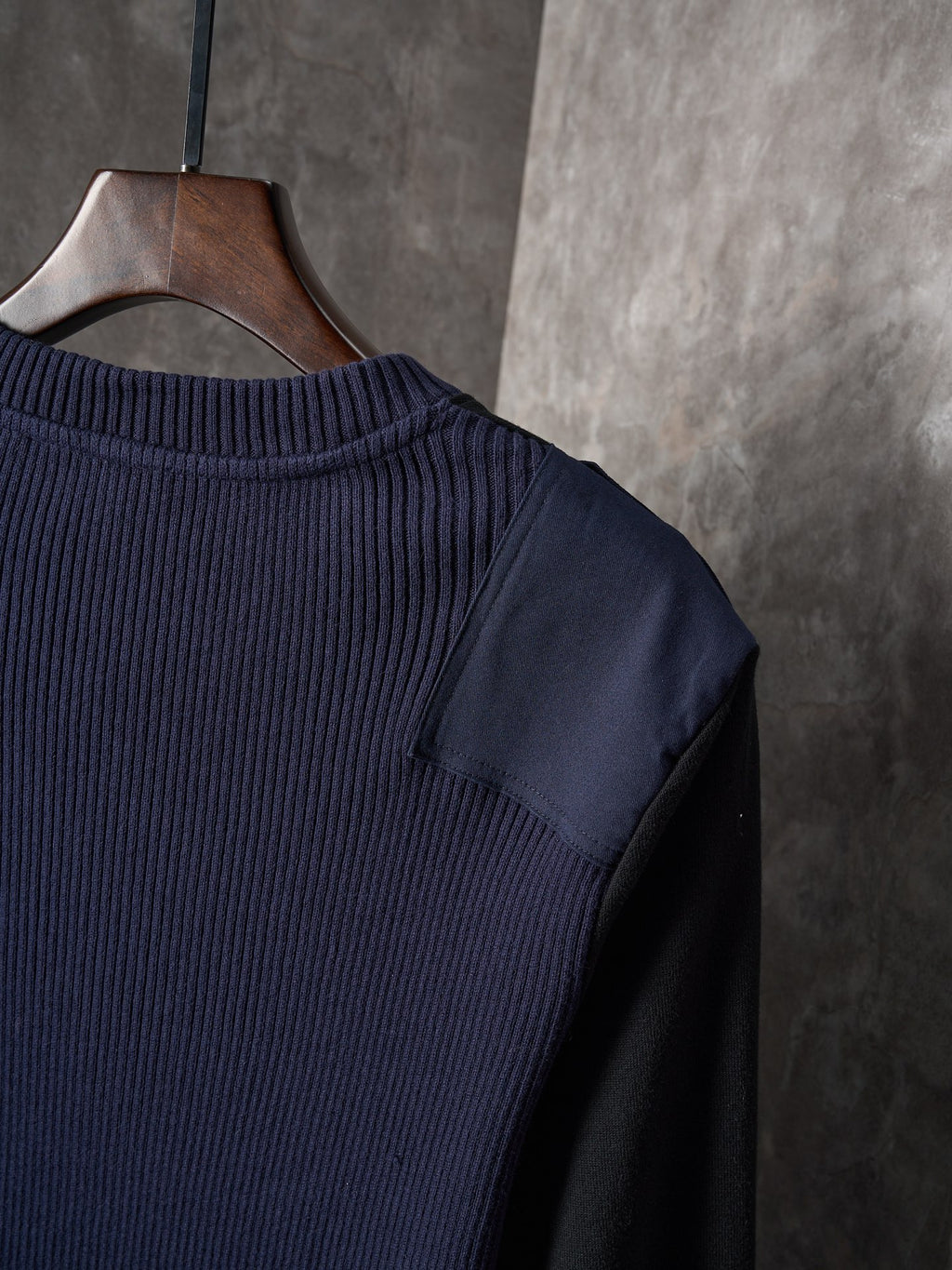 Dark ribbed knit sweater with crew neckline and shoulder seam detail