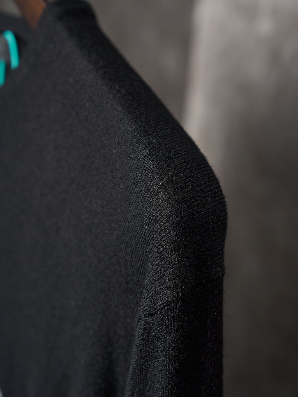 Black knit sweater sleeve with fine ribbed texture