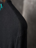 Black knit sweater sleeve with fine ribbed texture