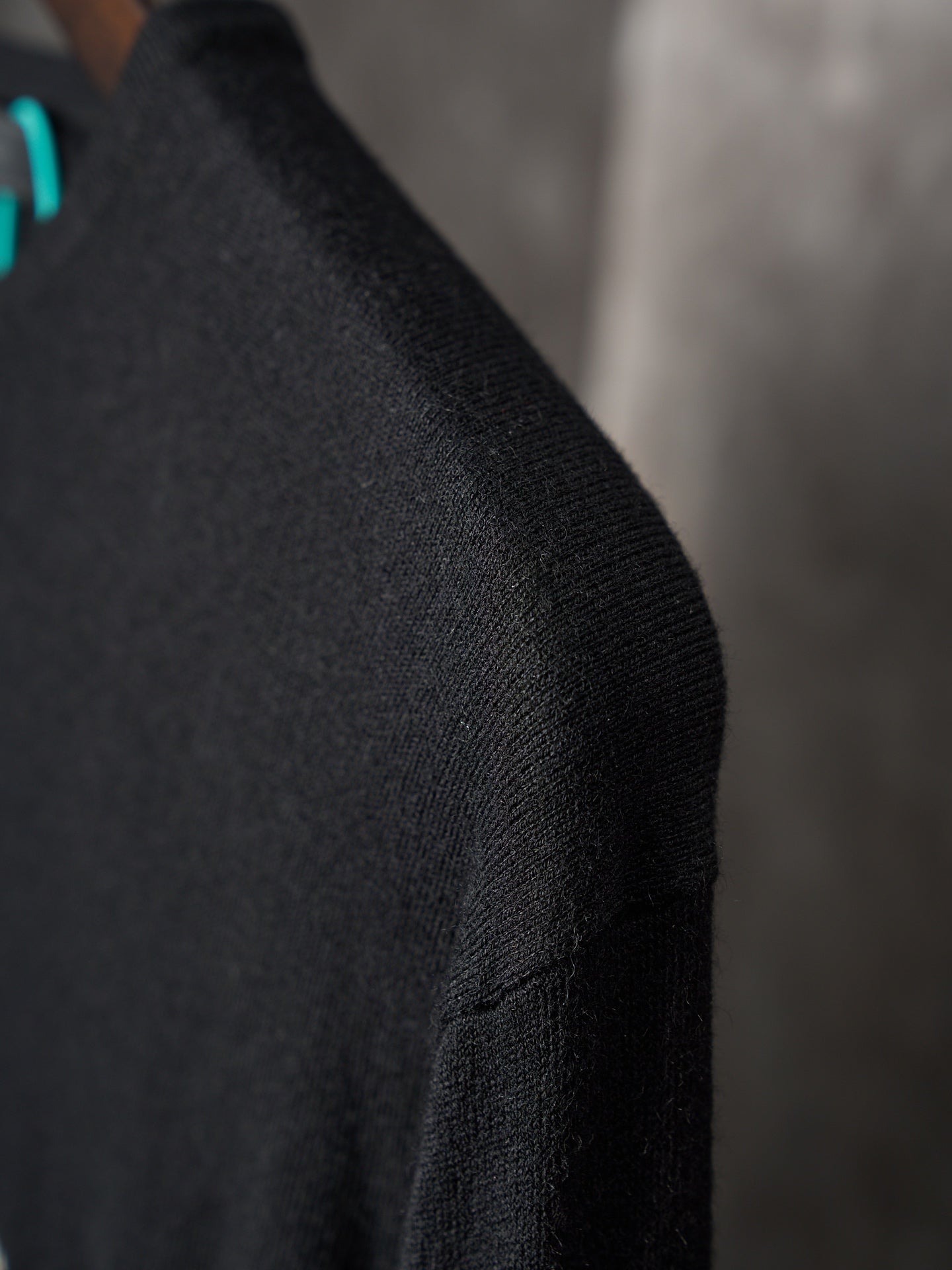Black knit sweater sleeve with fine ribbed texture