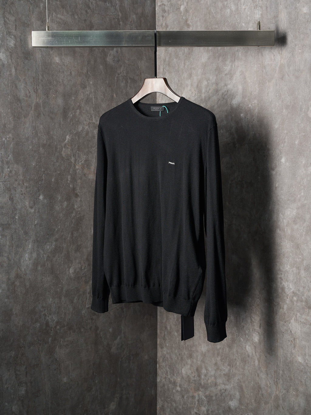 Black crewneck knit sweater with chest logo patch and long sleeves