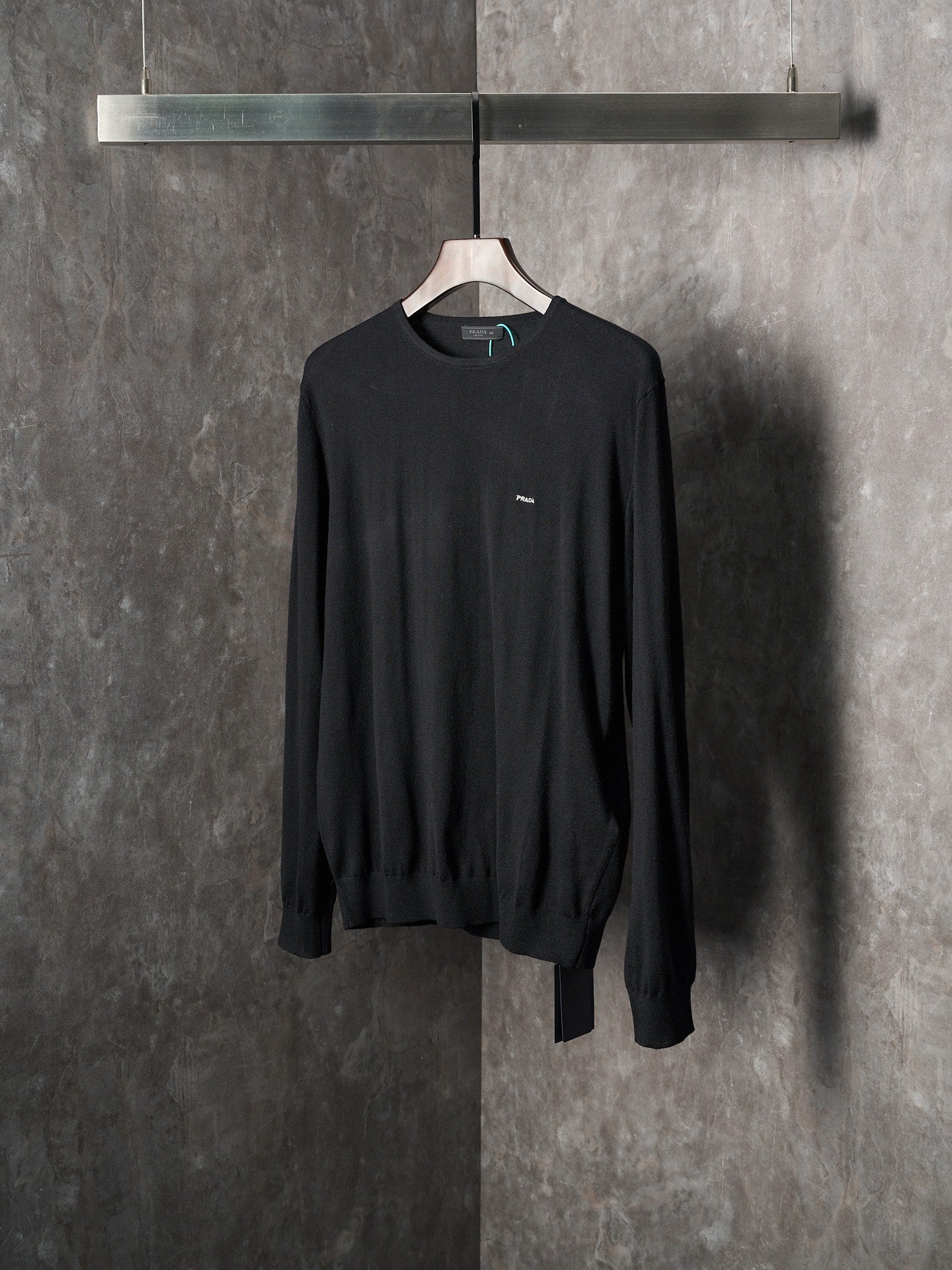 Black crewneck knit sweater with chest logo patch and long sleeves