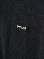 Close-up of PRADA embroidered logo on black knit sweater