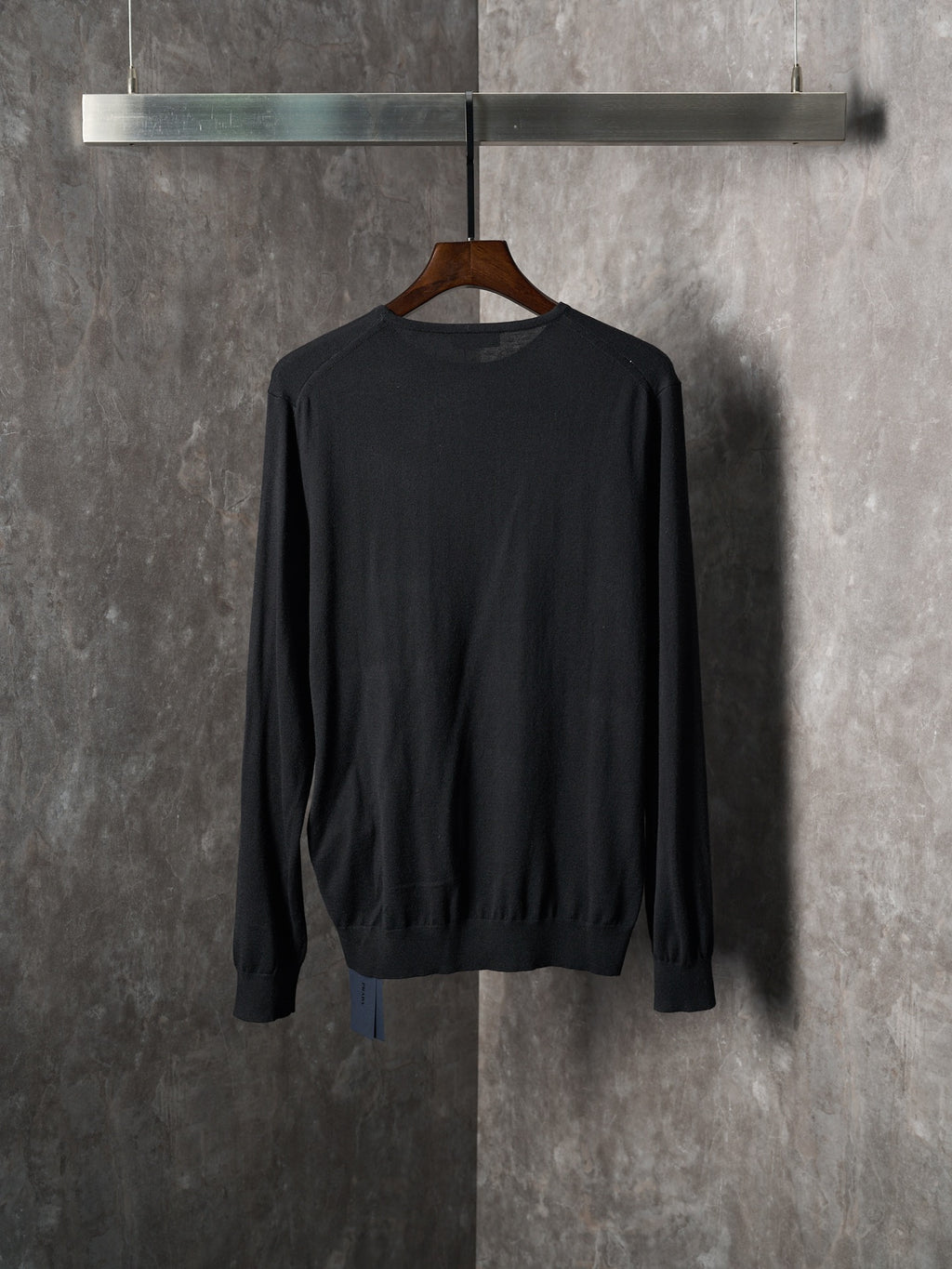 Black crewneck knit sweater on hanger, ribbed hem and cuffs