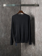 Black crewneck knit sweater on hanger, ribbed hem and cuffs