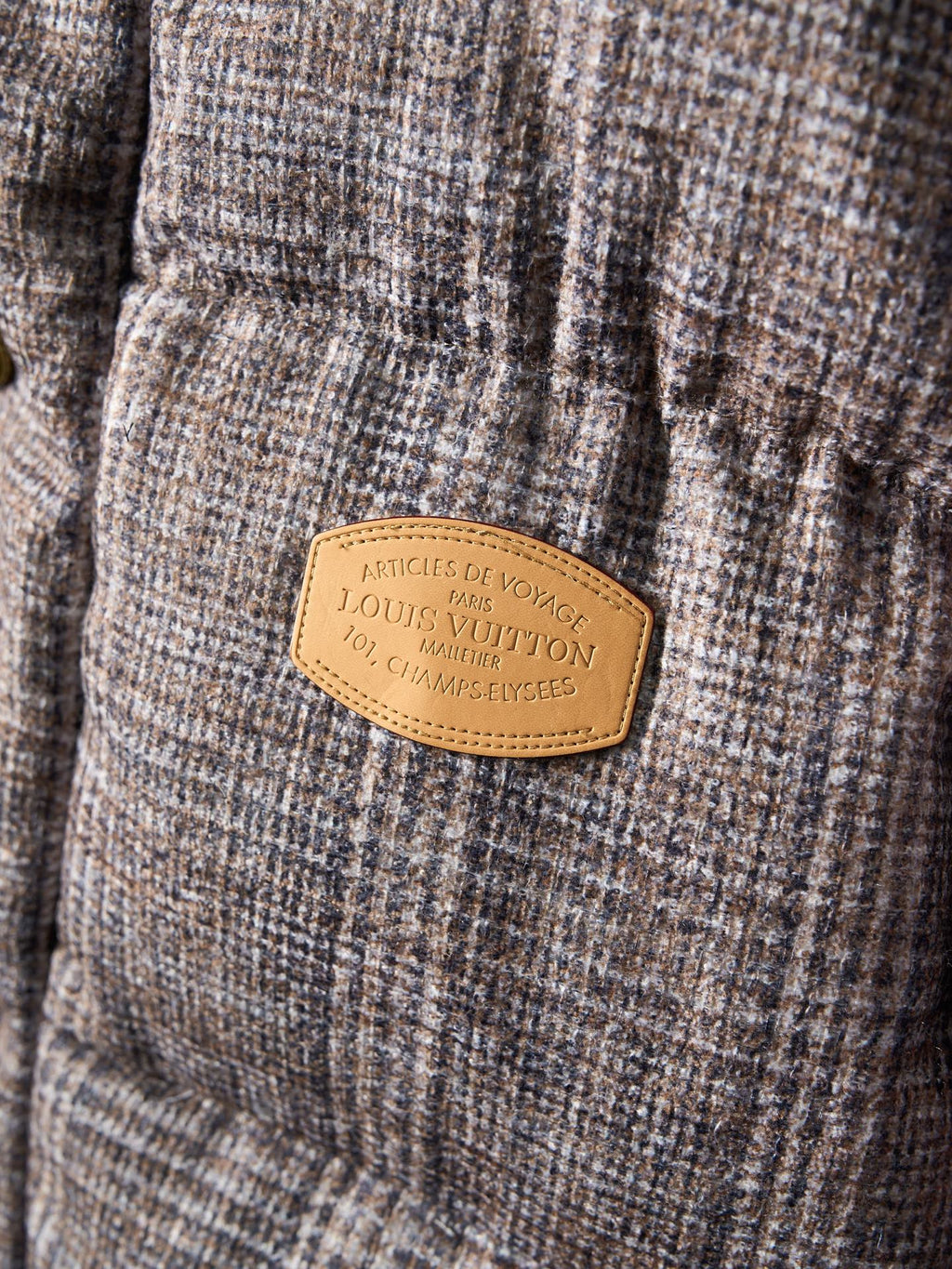 Louis Vuitton long puffer jacket tan brand label on textured fabric panel