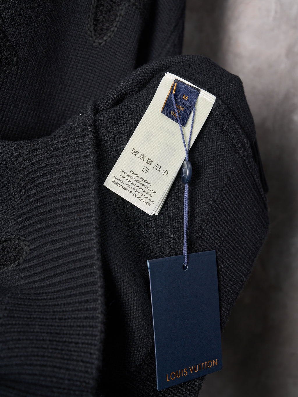 Black knit sweater with Louis Vuitton hang tag and small neck label