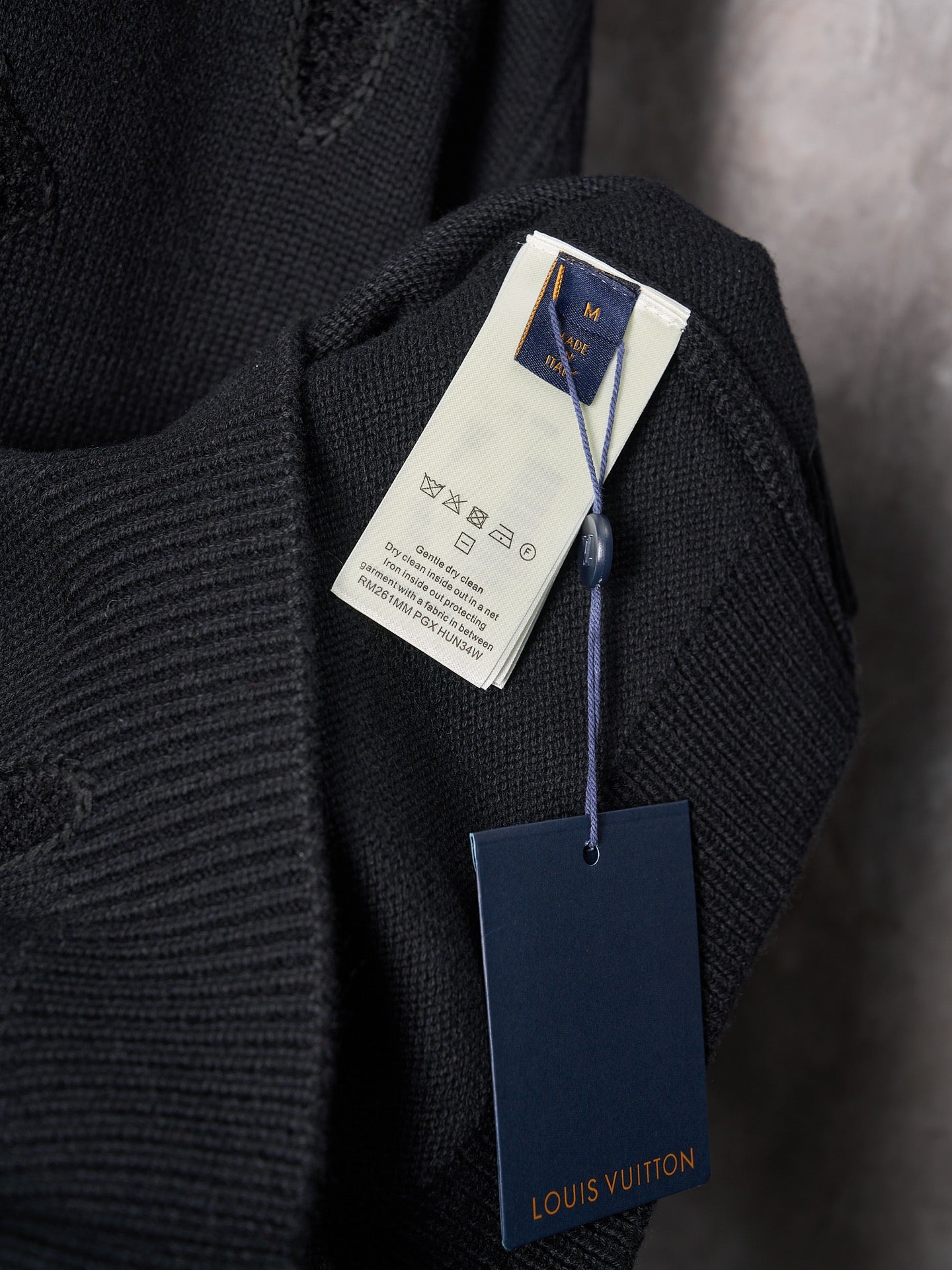 Black knit sweater with Louis Vuitton hang tag and small neck label