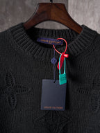 Black knit crewneck sweater with Louis Vuitton logo tag on hanger