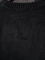 Black knit sweater with central monogram detail and ribbed collar